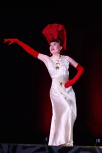 Céleste Vé Dette in a white dress with a black background